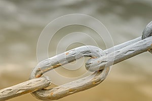 Metal chain on water background in sunlight/metal chain on water background in sunlight. Close up