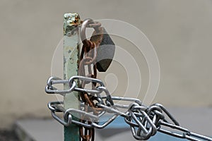 A metal chain wrapped around an iron pillar and locked.