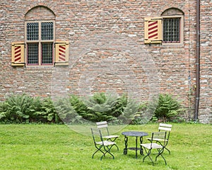 Metal chairs and table on a green lawn, at a 19th century Dutch castle photo