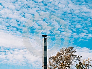 A metal chimney pipe made of stainless metal against a blue sky