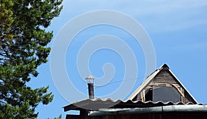 A metal chimney with traces of ash at the end of the pipes on a village house