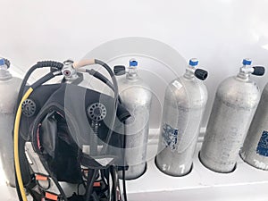 Metal chrome aluminum gas cylinders for breathing underwater, diving with valves, reducers and a black suit for diving with hoses