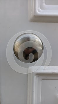 Metal chrome handle on white wooden door