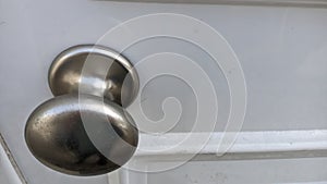 Metal chrome handle on white wooden door