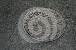 Metal circle of drain water on pavement