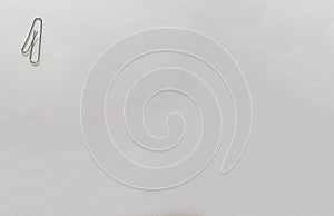 A metal clip in the form of the number one on a white sheet of Whatman paper. Paper clip isolate on a white background.The