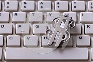 Metal clip waiting to be denominated in the form of the US dollar. Closeup of a white computer keyboard. The concept of earnings