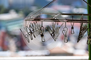 metal clothespins hanging with wire on blur background