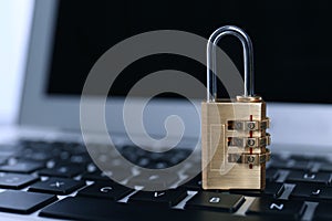 Metal code padlock on laptop keyboard, space for text. Cyber security concept