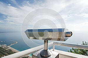 Metal coin operated telescope isolated at beautiful summer panoramic view at cityscape