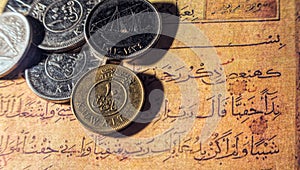 Coins of dinars, Kuwait national currency and lines from the Quran photo