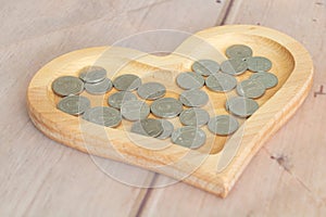 Metal coins in Moldovan lei currency 1 leu - 2lei in a heart-shaped wooden plate