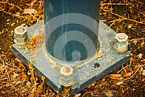 Metal column base or pikllar with big nuts mounted on the ground