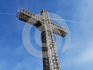 Metal construction christian cross with beautiful blue sky background.