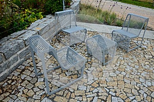 From metal constructions to climbing plants and vines is a sitting terrace of rough stone paving chipped cubes. metal gray furnitu