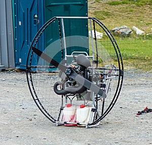 A metal contraption with a gas engine being used for paragliding