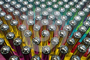 Metal cream chargers containing laughing gas and used as a legal high, reflecting colourful background.