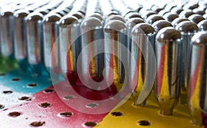 Metal cream chargers containing laughing gas and used as a legal high, reflecting colourful background.