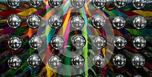 Metal cream puff chargers containing laughing gas and used as a legal high, reflecting colourful background.