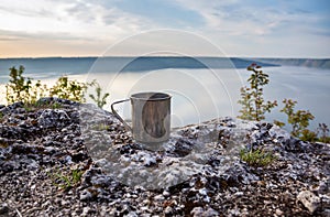 Metal cup in nature. Making coffee. Camping and summer vacation