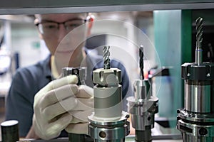 Metal-cutting cutters for a CNC machine in the hands of a worker to select tools