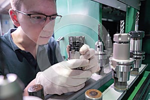 Metal-cutting cutters for a CNC machine in the hands of a worker to select tools