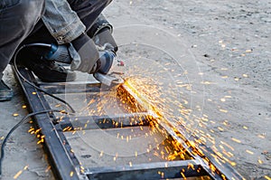 Metal cutting with an electric circular saw. Sparks fly in different directions. Blurred focus