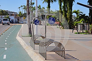 Metal cycle ports in public spaces, next to a cycle path and a sidewalk. photo