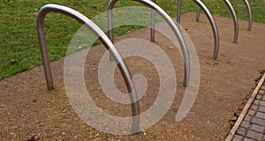 Metal cycle rack or stands on hardstanding beside grass lawn