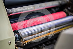 A metal cylinder together with a color dampening cylinder on an old printing press