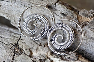 metal decorative oriental spirale design earrings on natural neutral background