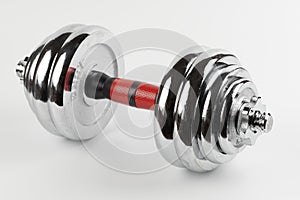 Metal demountable dumbbell with black plates and red handle isolated