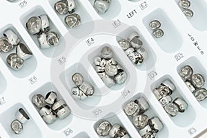 Metal dental crown samples in tray