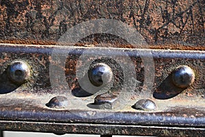 Metal detail riveted with rivets close-up.