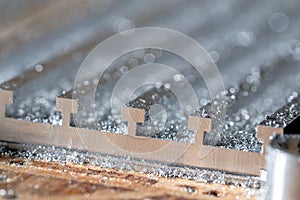 Metal detail in shiny steel shavings close up. Machining of metallic product for mechanical engineering, industry