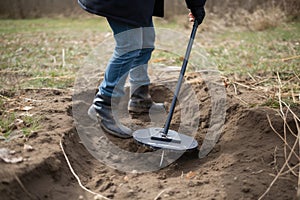 metal detector in action, with the detecting coil moving over the ground