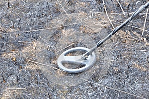 Metal detector. Search for metal artifacts on a field with damaged grass