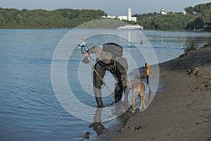 Treasure hunter is looking for a metal detector in the river