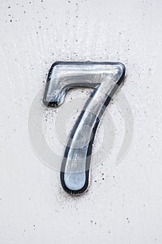 Metal digit - 7 on wooden background