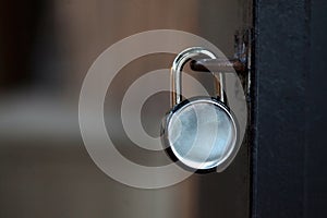 Metal door with closed metal padlock on blurred background