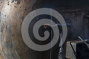 Metal door with deadbolts on a large old metal tank, background