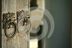 Metal door knob-knocker on the old rustical door.