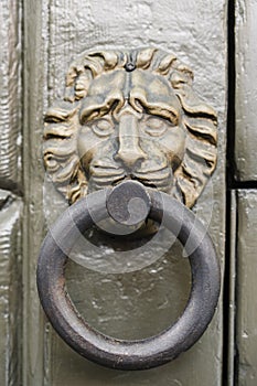Metal door knocker with a human face