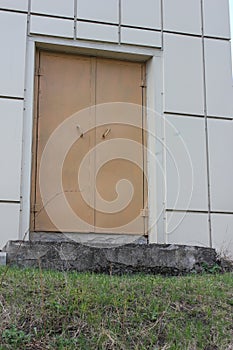 Metal door of sand colour consisting of two halves and having two holders