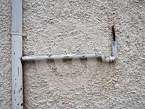 Metal drain pipe against a white wall