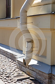 Metal drain pipe on the wall of a building