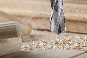 Metal drill bit make holes in wooden oaks plank