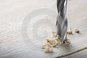 Metal drill bit make holes in wooden oaks plank