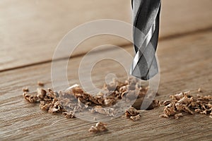 Metal drill bit make a holes in wooden oaks plank