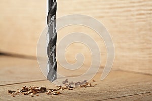 Metal drill bit make a holes in wooden oaks plank